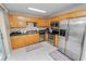 Bright kitchen with stainless steel appliances, wooden cabinets, and modern lighting fixtures at 114 Ed Padgett Rd, Lakeland, FL 33809