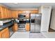 Modern kitchen with stainless steel appliances, wood cabinets, and tiled floors at 114 Ed Padgett Rd, Lakeland, FL 33809