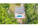 Aerial view of a home with screened enclosure, in-ground pool, patio, fenced backyard, and mature landscaping at 13 Count Fleet Dr, Ocala, FL 34482