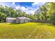 Large backyard with a lush green lawn and mature trees creating a serene outdoor space at 13 Count Fleet Dr, Ocala, FL 34482