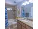 Bathroom with shower-tub combo, a window, and a sink with dark wooden cabinets and a granite countertop at 13 Count Fleet Dr, Ocala, FL 34482