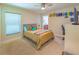 Bedroom with tan carpet, a ceiling fan, and a bed with a patterned blanket and decorative pillows at 13 Count Fleet Dr, Ocala, FL 34482