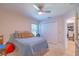Bedroom with tan carpet, a ceiling fan, and a bed with blue bedding and decorative pillows at 13 Count Fleet Dr, Ocala, FL 34482