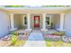 Inviting front porch with stone-clad columns, tiled floor, and a vibrant red front door at 13 Count Fleet Dr, Ocala, FL 34482