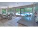 Screened-in patio with an outdoor kitchen and bar seating overlooking the sparkling in-ground pool at 13 Count Fleet Dr, Ocala, FL 34482