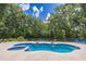 In-ground pool with built-in spa surrounded by lush landscaping, chairs, and wooded views at 13 Count Fleet Dr, Ocala, FL 34482