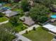 Aerial shot of a home with a large backyard, swimming pools in the neighborhood, and mature landscaping at 1308 Timberidge N Loop, Lakeland, FL 33809