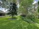 Lush backyard with mature trees, green grass, and landscaped garden beds at 1308 Timberidge N Loop, Lakeland, FL 33809