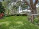 Lush backyard features a swing beneath a large tree, providing a serene and relaxing outdoor space at 1308 Timberidge N Loop, Lakeland, FL 33809