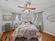 Comfortable bedroom features a ceiling fan, natural light, and hardwood floors at 1308 Timberidge N Loop, Lakeland, FL 33809