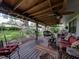 Inviting covered patio with ceiling fans and comfortable seating, perfect for outdoor relaxation and entertaining overlooking a grassy yard at 1308 Timberidge N Loop, Lakeland, FL 33809