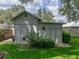 Charming storage shed with double doors, surrounded by lush greenery, adding functionality and character to the backyard at 1308 Timberidge N Loop, Lakeland, FL 33809