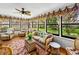Bright sunroom with multiple windows offering scenic backyard views and comfortable seating at 1308 Timberidge N Loop, Lakeland, FL 33809