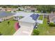 Aerial view of house showcasing solar panels, two-car garage and manicured lawn at 1420 Meadows Pond Dr, Bartow, FL 33830