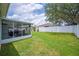 Fenced backyard featuring a patio with outdoor seating and green grass at 1420 Meadows Pond Dr, Bartow, FL 33830