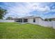 Expansive backyard features well-kept lawn and screen enclosed lanai with white fence at 1420 Meadows Pond Dr, Bartow, FL 33830