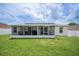 Backyard features a screened-in lanai, manicured lawn and a white vinyl fence at 1420 Meadows Pond Dr, Bartow, FL 33830