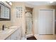 Bright bathroom with a white vanity, granite countertop, and a tiled glass-enclosed shower at 1420 Meadows Pond Dr, Bartow, FL 33830