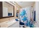 Well-lit bathroom with a turtle-themed shower curtain and vanity with a granite countertop at 1420 Meadows Pond Dr, Bartow, FL 33830