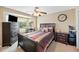 Cozy bedroom with dark wood furniture, ceiling fan, and natural light from the bay window at 1420 Meadows Pond Dr, Bartow, FL 33830