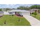 Well-manicured lawn and landscaping, a red walkway, and a two-car garage at 1420 Meadows Pond Dr, Bartow, FL 33830