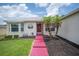 Up close shot of a cozy home with a red door, landscaping, and decorative front yard at 1420 Meadows Pond Dr, Bartow, FL 33830