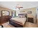 Spacious main bedroom featuring a ceiling fan, a dresser with a mirror, and side tables at 1420 Meadows Pond Dr, Bartow, FL 33830