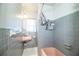 Cozy bathroom with a pink sink and bathtub, gray tile, and white accents at 1604 Park Dr, Lakeland, FL 33803