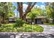 Attractive one-story home with a long driveway, lush lawn, and mature shade trees creating inviting curb appeal at 1604 Park Dr, Lakeland, FL 33803