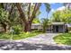 Attractive one-story home with a long driveway, green lawn, and mature shade trees creating stunning curb appeal at 1604 Park Dr, Lakeland, FL 33803