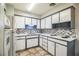 Efficient kitchen featuring white cabinetry, neutral backsplash, and tile flooring at 1604 Park Dr, Lakeland, FL 33803