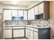 Well-lit kitchen featuring white cabinets, gray accents, modern appliances, and stylish backsplash at 1604 Park Dr, Lakeland, FL 33803