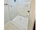 Walk-in shower featuring stylish marble-look tile, glass door, and black fixtures at 1683 Sw 3Rd St, Ocala, FL 34471