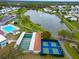 Aerial view of community tennis courts, pool, clubhouse, and lake with walking paths at 1811 Sherwood Hill Dr, Lakeland, FL 33810