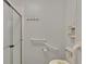 Accessible bathroom featuring grab bars, shower with a glass door, and toilet with printed design at 1811 Sherwood Hill Dr, Lakeland, FL 33810