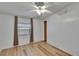 Bright bedroom with wood-look floors, ceiling fan, and a window with blinds at 1811 Sherwood Hill Dr, Lakeland, FL 33810