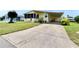 Charming yellow home featuring a spacious carport and well-manicured lawn at 1811 Sherwood Hill Dr, Lakeland, FL 33810