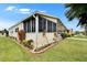 Exterior view of the home highlighting the siding, enclosed porch, and landscaped yard at 1811 Sherwood Hill Dr, Lakeland, FL 33810