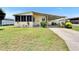 Inviting home with a cozy screened porch, carport, and lush front yard at 1811 Sherwood Hill Dr, Lakeland, FL 33810