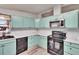 Eat in kitchen featuring blue cabinets and black appliances at 1811 Sherwood Hill Dr, Lakeland, FL 33810