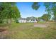 Backyard view of the house with lots of yard space, lush grass, and tall trees at 1830 Casco, Lakeland, FL 33801