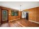 Charming dining room with wood paneling, hardwood floors, and a view into the kitchen at 1830 Casco, Lakeland, FL 33801