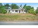 Charming single-story home with a white exterior, well-maintained lawn, and mature trees, creating an inviting curb appeal at 1830 Casco, Lakeland, FL 33801