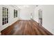 Spacious living room featuring rich wood floors, fresh white walls, natural light and stylish glass paneled doors at 1830 Casco, Lakeland, FL 33801