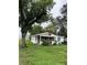 Front exterior of a house with an overgrown front yard and large tree at 1938 Lavon St, Lakeland, FL 33805