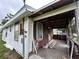 Exterior showing the porch and the damage, along with a cluttered area at 1938 Lavon St, Lakeland, FL 33805