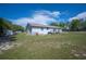 Backyard view of home showcasing well-maintained lawn, patio, and exterior features at 1948 Oakland Park Dr, Lake Wales, FL 33898