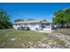 Backyard view of house featuring a grill, patio, and golf carts on a large, grassy lot at 1948 Oakland Park Dr, Lake Wales, FL 33898