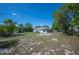 Expansive backyard featuring mature trees, lush lawn, and a charming home in the background at 1948 Oakland Park Dr, Lake Wales, FL 33898