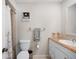 Functional bathroom features a toilet, vanity, and a tub with a shower behind a floral curtain at 1948 Oakland Park Dr, Lake Wales, FL 33898